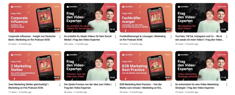YouTube-Videovorschläge des Channels „morefire“ mit insgesamt acht Thumbnails zu Podcastfolgen und Expertentalks. Die obere Reihe zeigt u. a. Episoden zu Corporate Influencern, Tipps für ideale Social-Media-Videos und Strategien zur Videoplatzierung. In der unteren Reihe finden sich Inhalte zu ungewöhnlichen Marketingstellen, der Prozessentwicklung von der Idee zum Video, B2B-Marketing und strategischer Videoplanung. Die Thumbnails sind in Rot- und Orangetönen gehalten oder zeigen zwei Männer vor einer Kamera im Studio-Setting.