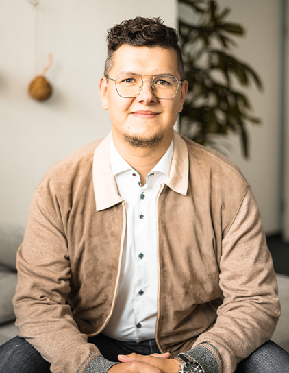 Dominic Lua im modernen Büro sitzend, Teamfoto