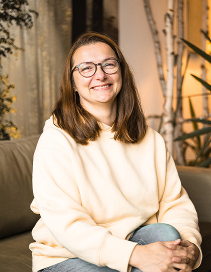 Edita Grunenberg lächelnd im Büro sitzend, Teamfoto
