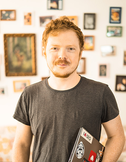 Florian Esser lächelt in die Kamera und trägt ein graues T-Shirt