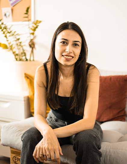 Gayane Margaryan sitzt an einem Tisch und trägt ein gemustertes Oberteil