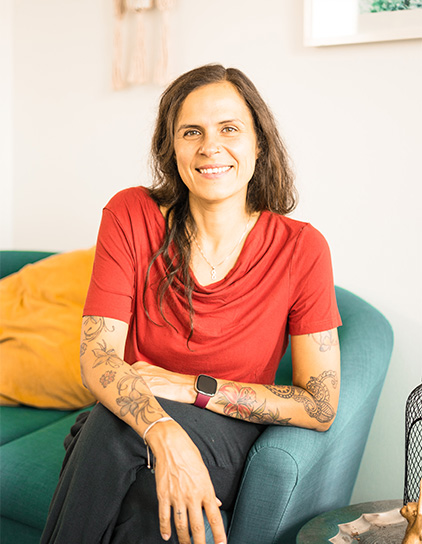 Portrait von Karolin Sterz-Buchholz, lächelnd und in einem roten Shirt im Büro von Morefire