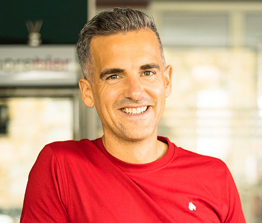 Robin Heintze in einem roten T-Shirt, lächelt in die Kamera