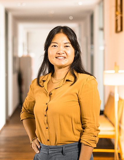 Xuan Gehlhar in einem orangefarbenen Hemd, lächelt in die Kamera