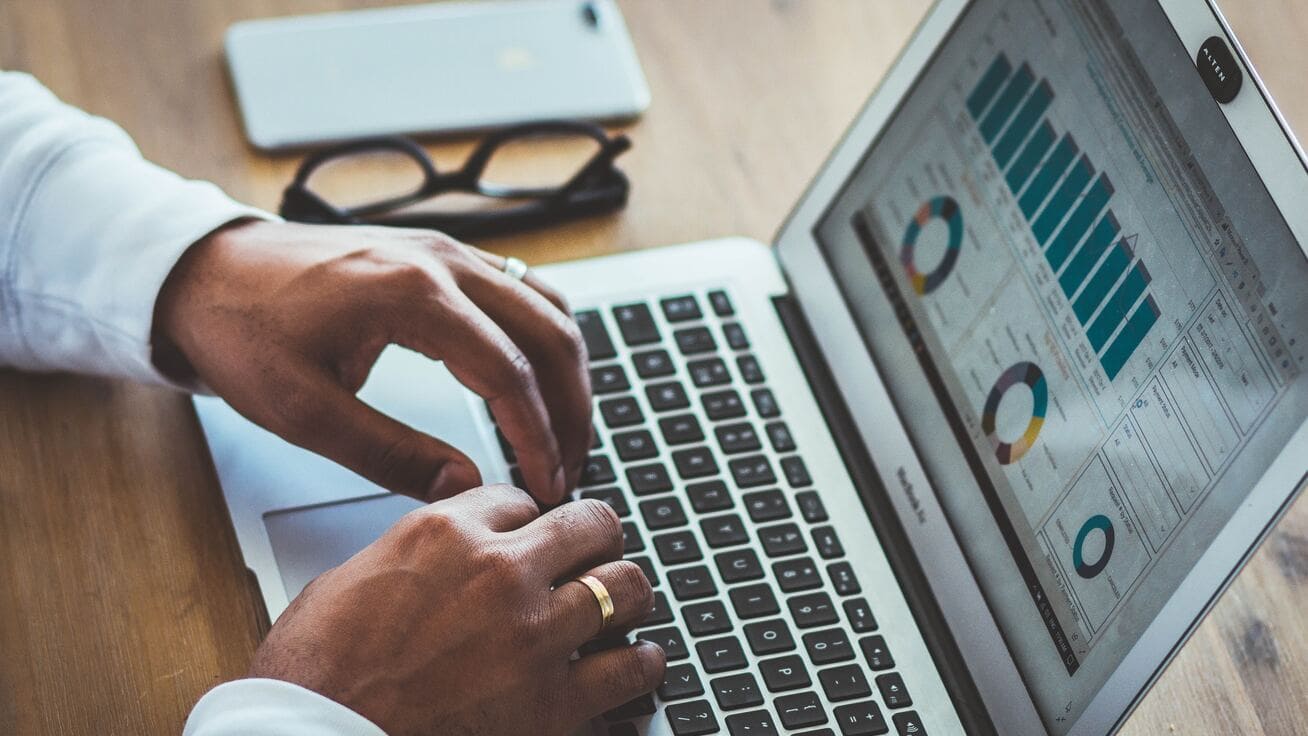 Person analysiert Daten auf einem Laptop mit Diagrammen